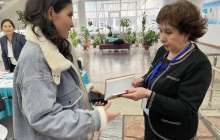 Сайлау учаскесіне келген балаларға кітаптар беріліп жатыр