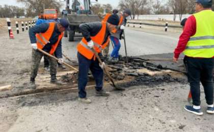 Үштөбеде жол жөндеушілер теміржол рельсі үстінен асфальт төсеп тастаған