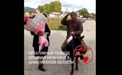Есекке мініп, әйелінің жұмыс істейтін мектебіне гүл алып келген ер адам желі қолданушыларын тәнті етті (видео)