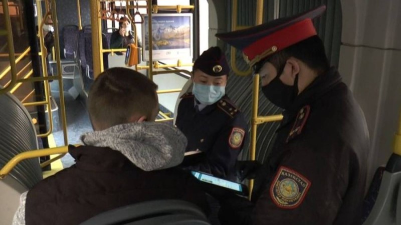 Алматыда полицейлер қоғамдық көліктің жолаушыларын тексеріп жатыр  