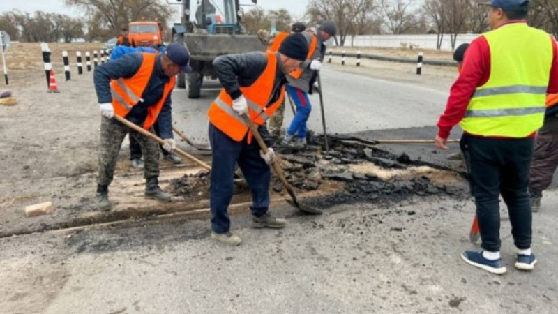 Үштөбеде жол жөндеушілер теміржол рельсі үстінен асфальт төсеп тастаған
